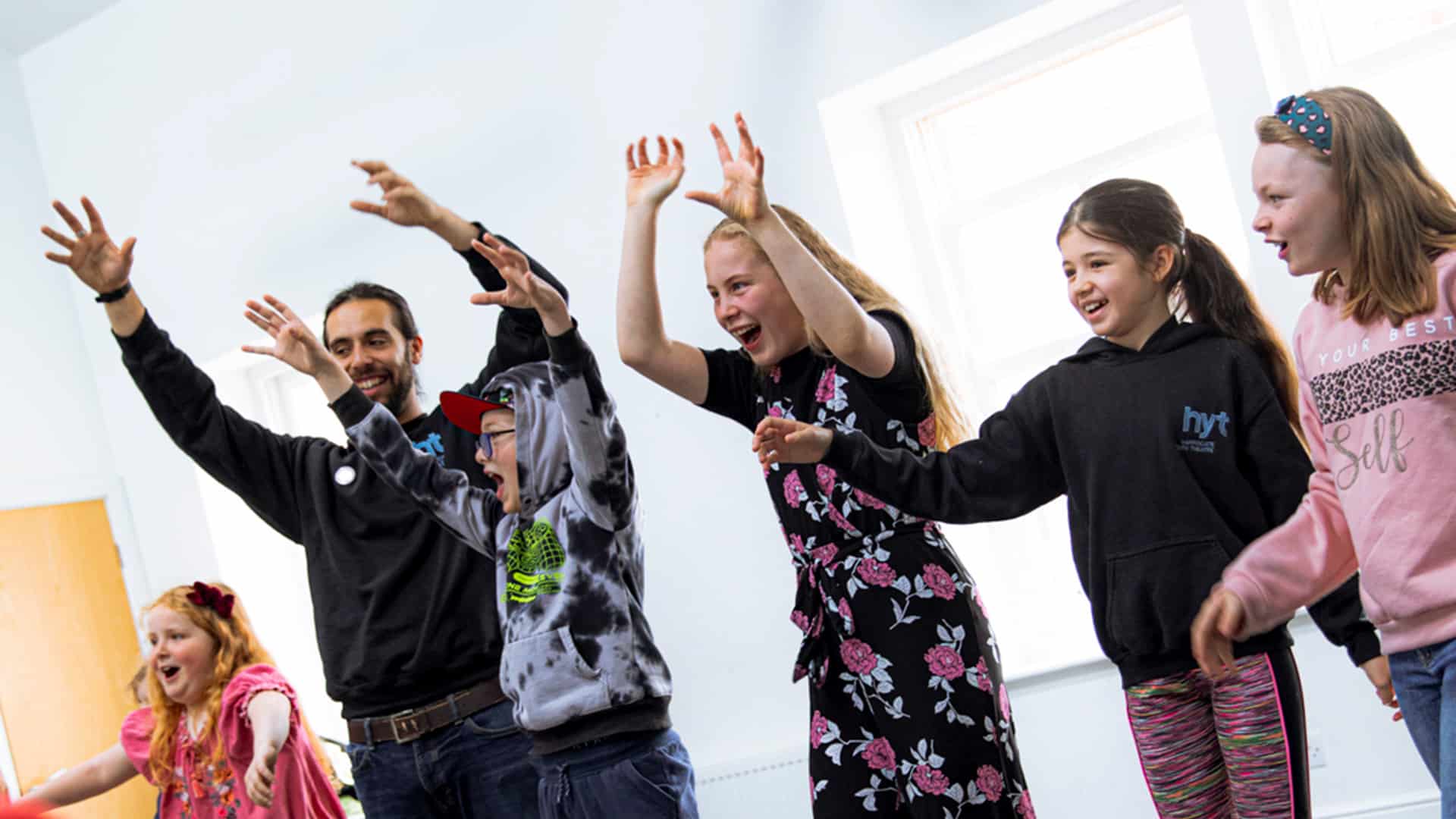 Group of children doing an acting exercise waving hands in the air