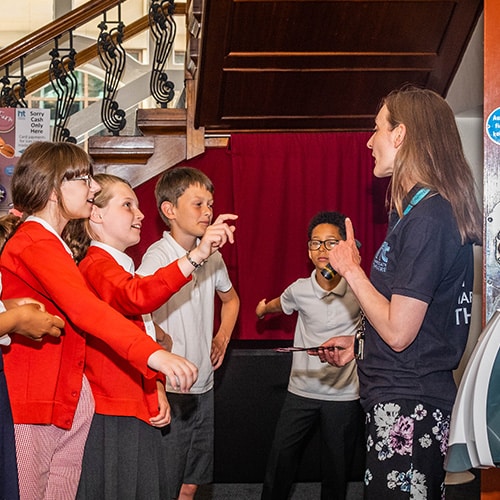 Youth group with teacher showing them round the theatre