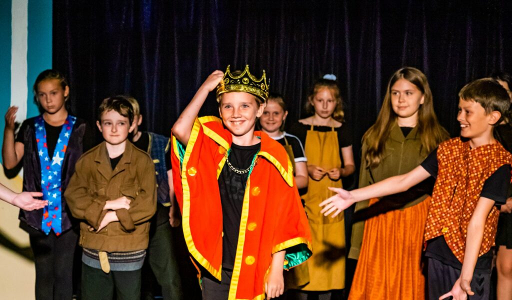 Harrogate Youth Theatre in costume on stage similing