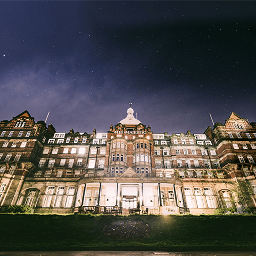 Exterior shot of The Majestic Hotel at night time lit up