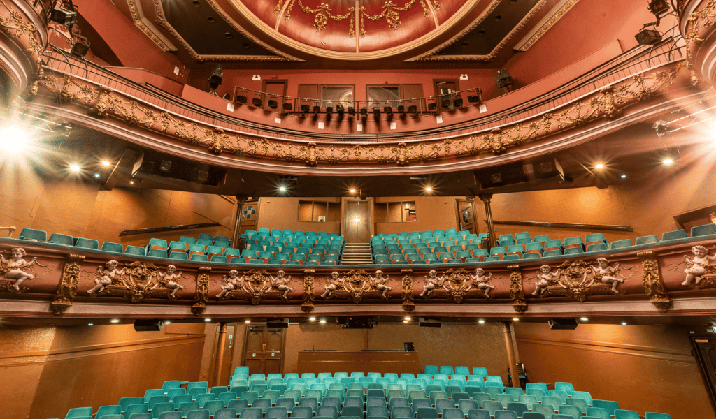 Interior of theatre, blue seats and lights facing toward stage